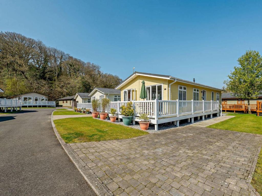 a yellow house with a porch and potted plants at 2 Bed in Narberth oc-91799 in Stepaside