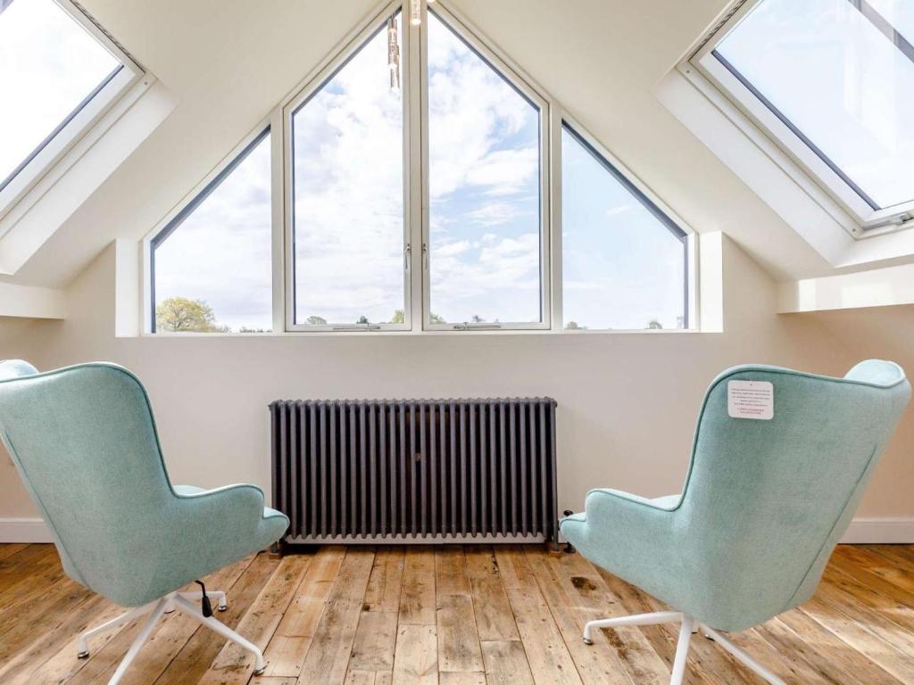 two chairs sitting in a room with windows at 2 Bed in Ellesmere oc-62544 in Ellesmere