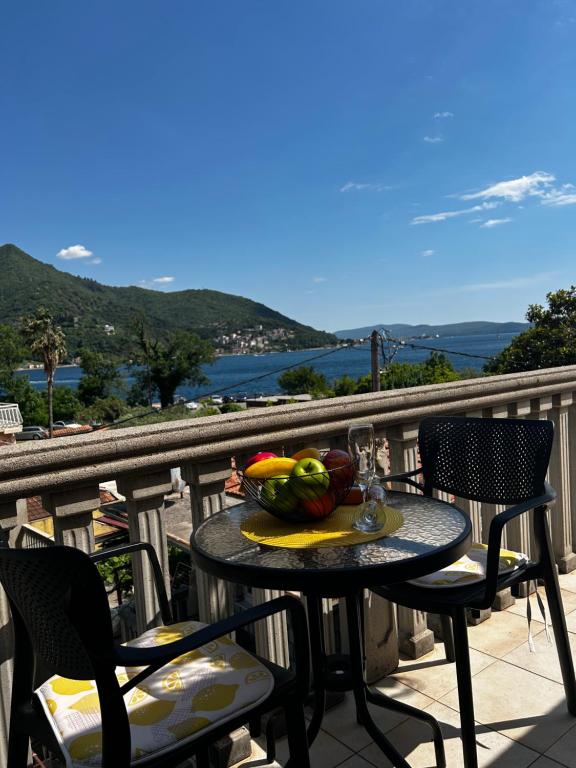 a table with a bowl of fruit on a balcony at Apartmani Gušti in Kamenari