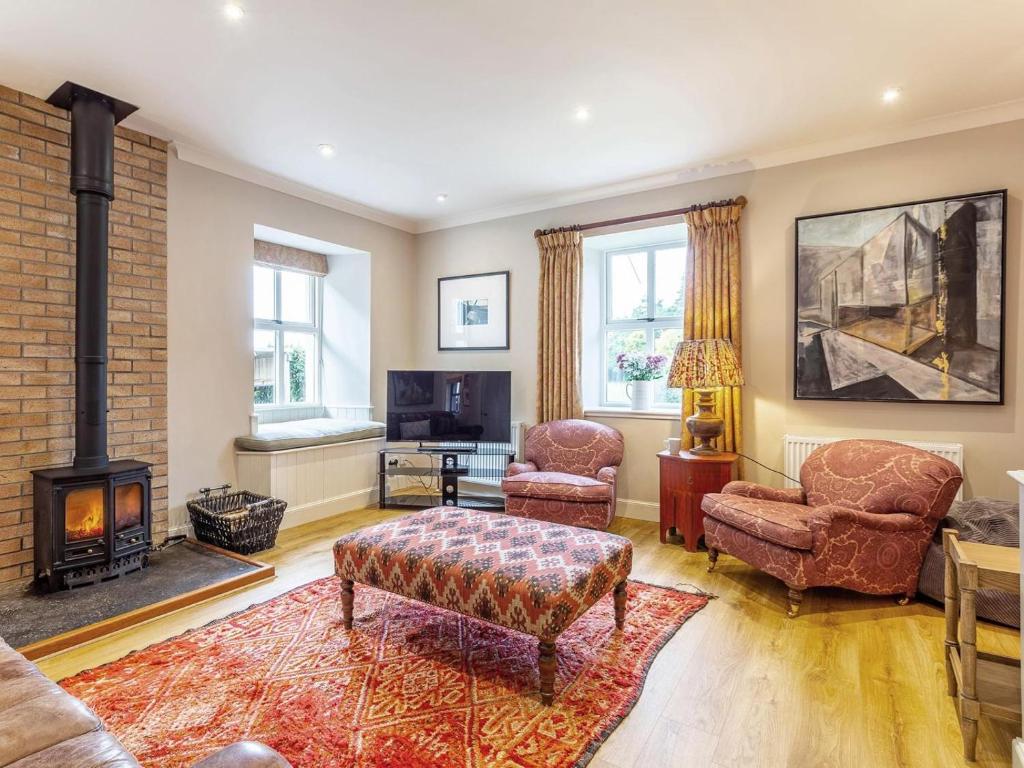 a living room with a fireplace and two chairs at 1 Bed in Forres oc-78430 in Forres
