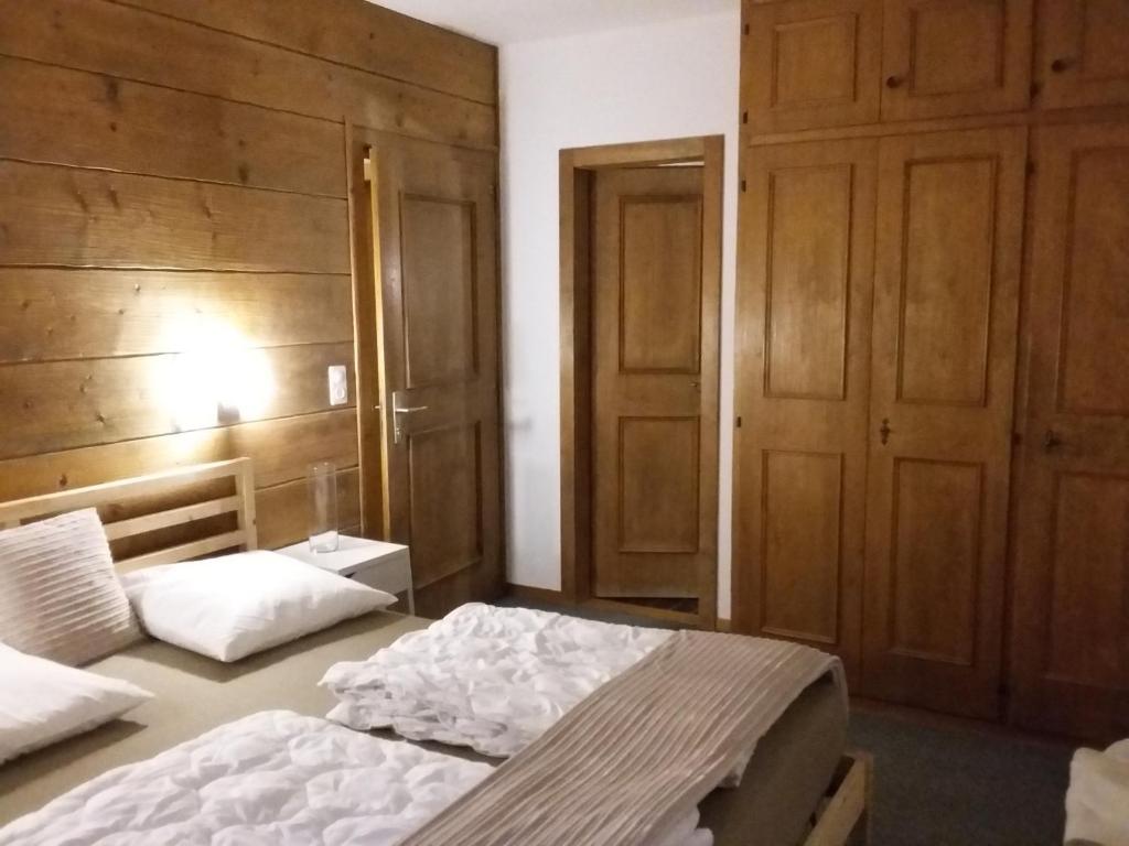 1 Schlafzimmer mit 2 Betten mit Holzwänden und -türen in der Unterkunft Maya Joie in La Fouly