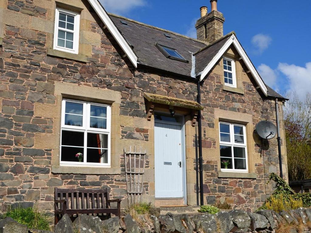 a stone house with a white door and a bench at 2 Bed in Duns oc-48811 in Duns