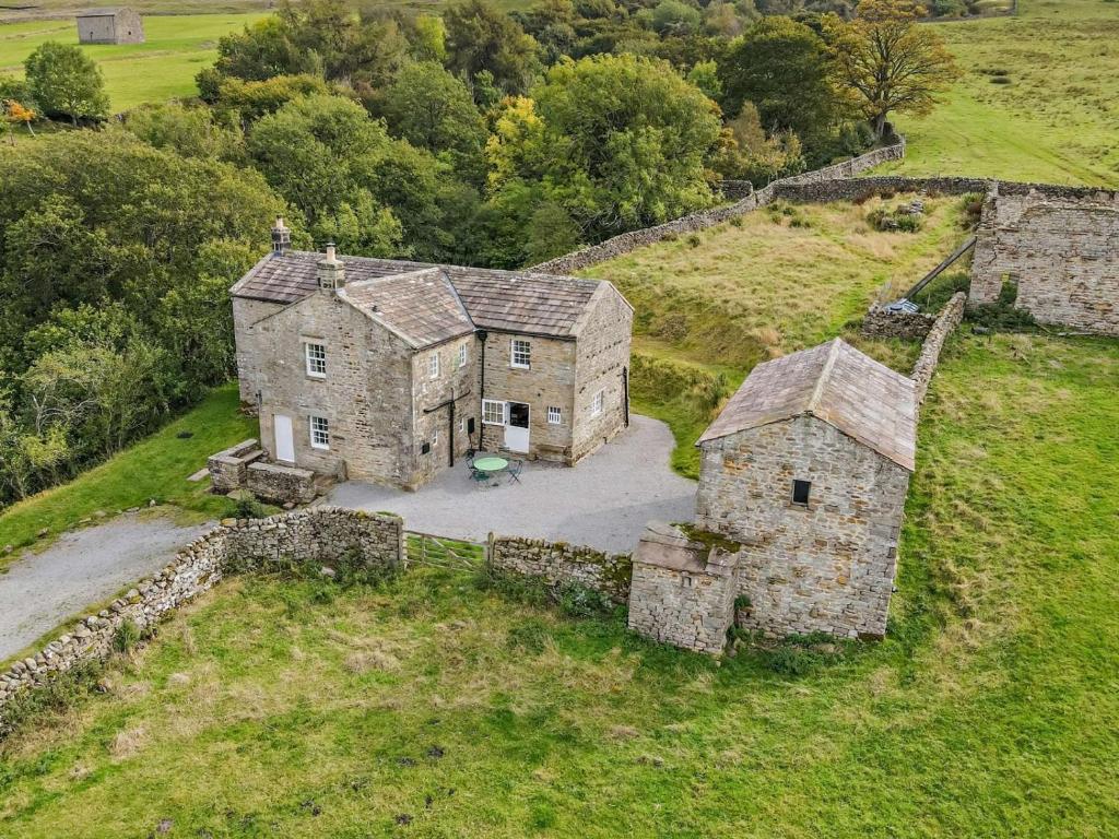 an aerial view of an old stone house in a field at 4 Bed in Leyburn oc-g0008 in Gammersgill