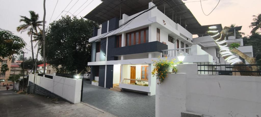 a white house with a black and white facade at RITU CAPITOL Homestay in Trivandrum