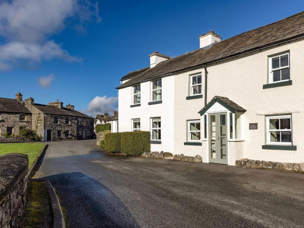 a white house with a driveway in a village at 1 Bed in Grange-over-sands oc-78659 in Cartmel