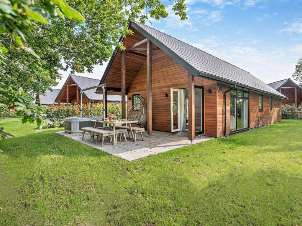 a wooden house with a picnic table in a yard at 2 Bed in Swansea oc-91728 in Killay