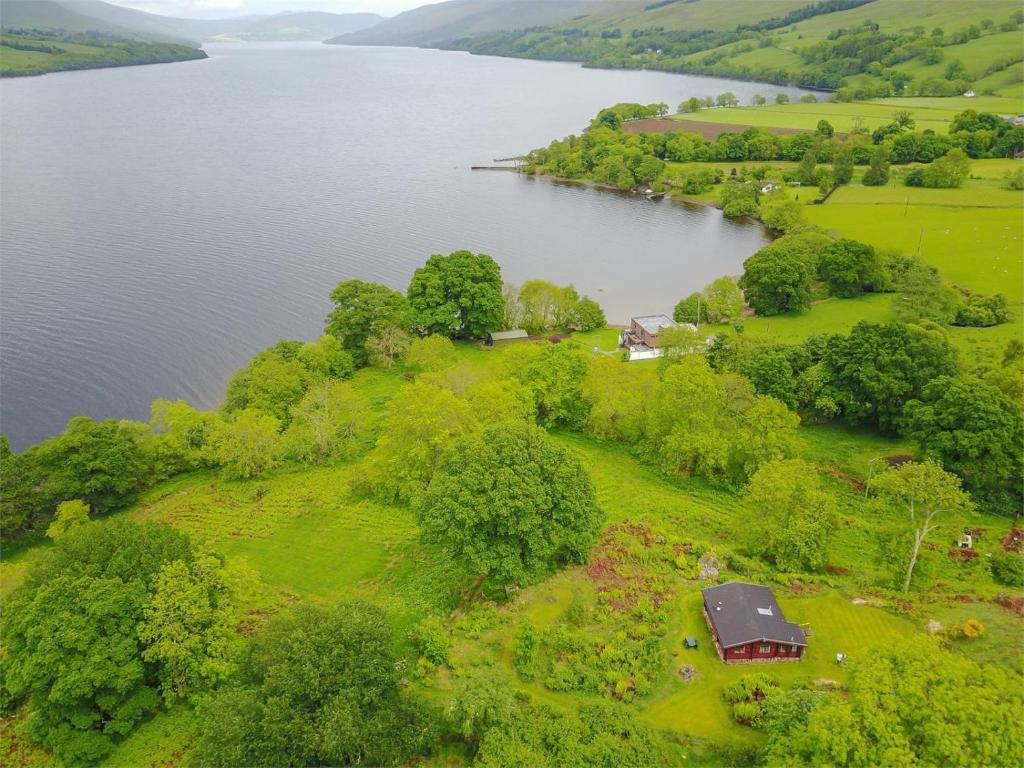 an aerial view of a lake with a house and trees at 2 Bed in Killin oc-ca351 in Ardeonaig