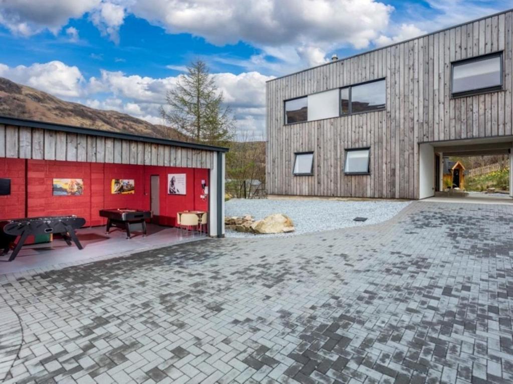 a house with a red wall and a patio at 3 Bed in Kinlochleven oc-87130 in Kinlochleven
