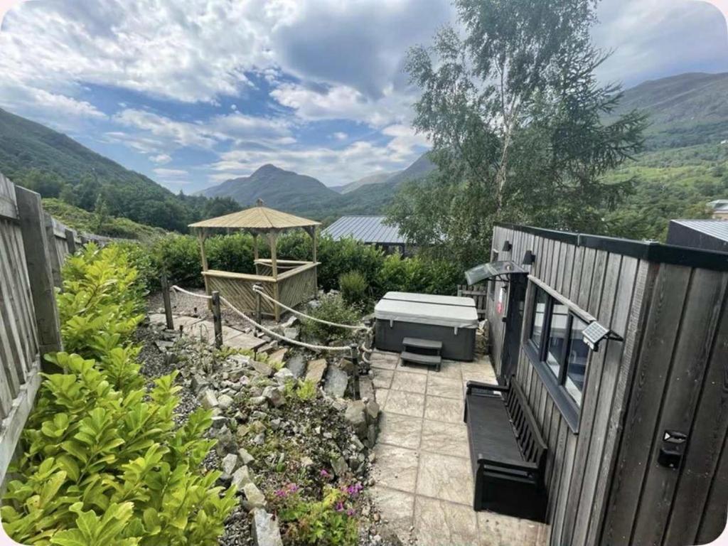 a garden with a bench and a table and umbrella at 1 Bed in Kinlochleven oc-87131 in Kinlochleven