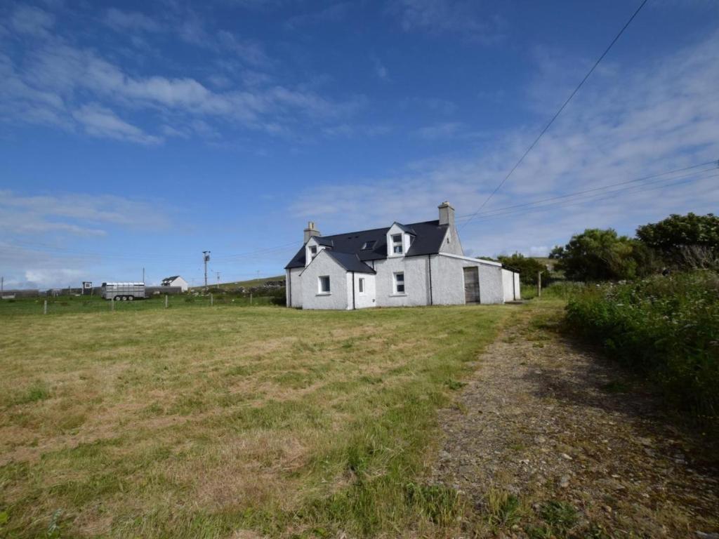 a white house in the middle of a field at 3 Bed in Isle Of North Uist oc-77239 in Sollas
