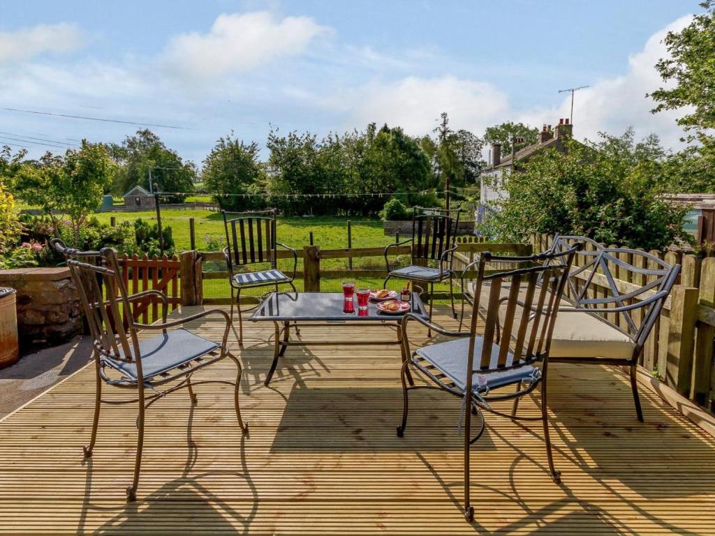 a patio with three chairs and a table and a table and chairs at 2 Bed in Kirkby Thore oc-78744 in Kirkby Thore
