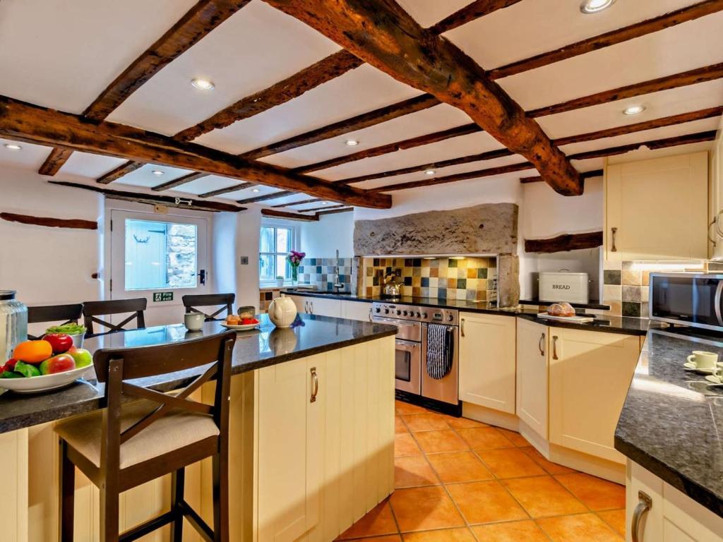 a large kitchen with white cabinets and a ceiling with exposed beams at 3 Bed in Grange-over-sands oc-95100 in Cark