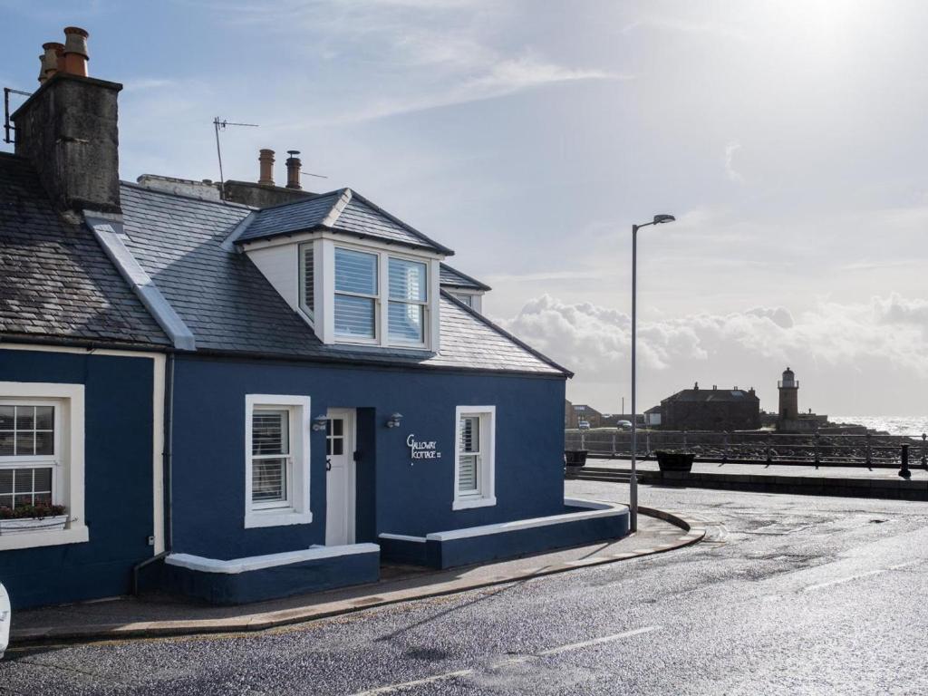 a blue house sitting on the side of a street at 3 Bed in Stranraer oc-77308 in Portpatrick