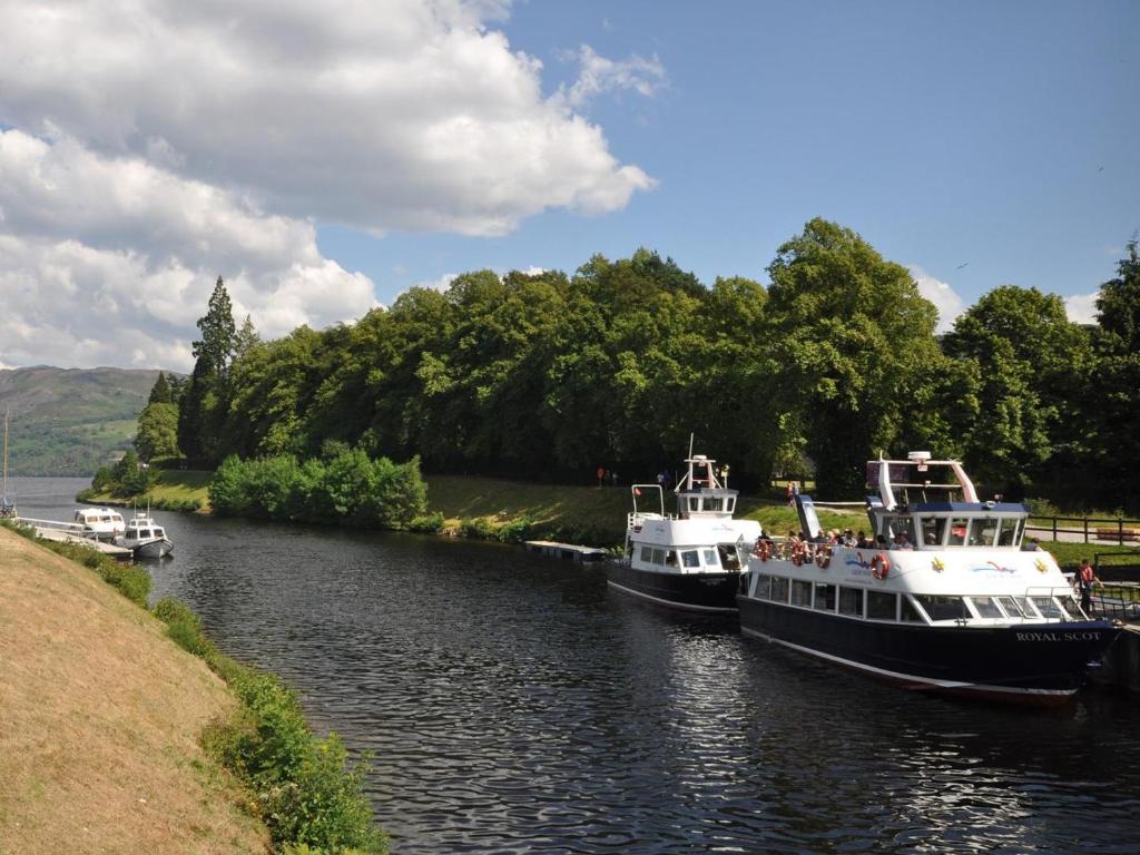 two boats are docked on a river at 2 Bed in Fort Augustus oc-in637 in Fort Augustus