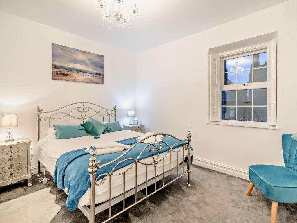 a bedroom with a bed and a blue chair at 2 Bed in Morecambe oc-93719 in Heysham