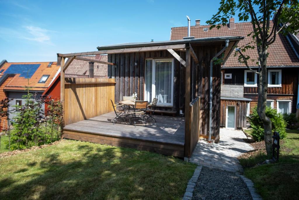 a wooden deck with a table and chairs on it at Ferienhaus "Zum Lochstein" in Sankt Andreasberg