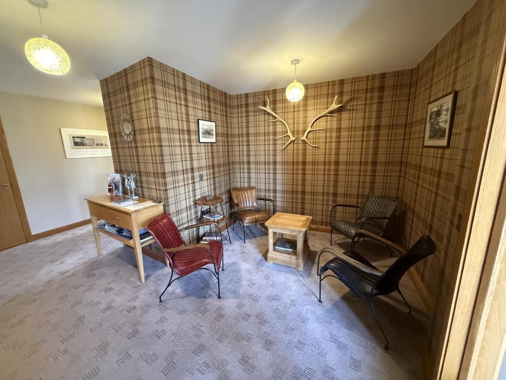 a waiting room with chairs and tables in a room at Avalon Guest House in Orkney