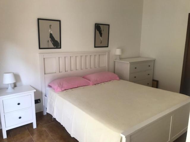 a bedroom with a large white bed with pink pillows at casa vacanze da Tony 2 in San Benedetto del Tronto
