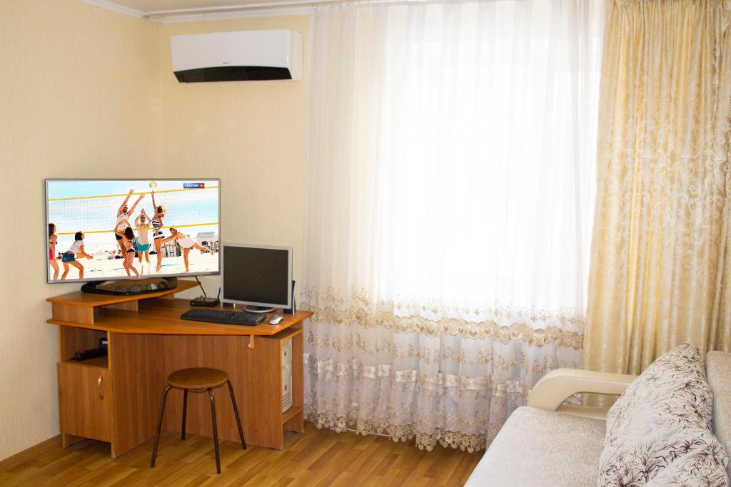 TuymazyにあるОтличная 2-к квартира в Туймазахのデスク、パソコン、テレビが備わる客室です。