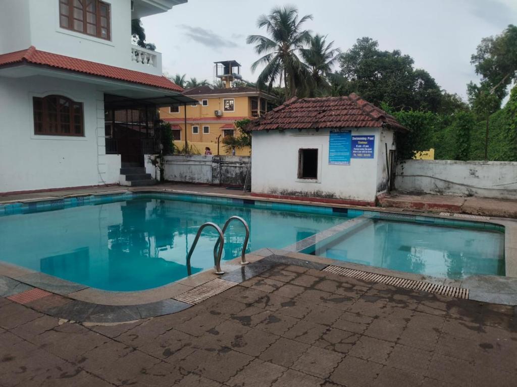 a swimming pool in front of a house at The Coastal Villa Arpora in Parra
