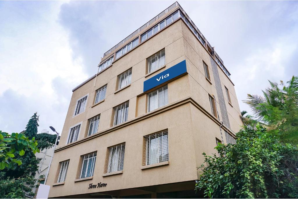 a tall building with a blue sign on it at Via Shree Haree Residency in Pune