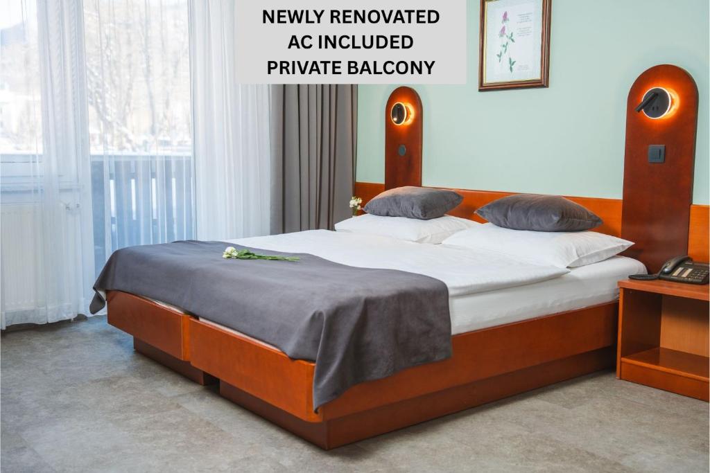 a bedroom with a large bed with white sheets and pillows at Hotel Tripič, restaurant and pizzeria in Bohinj