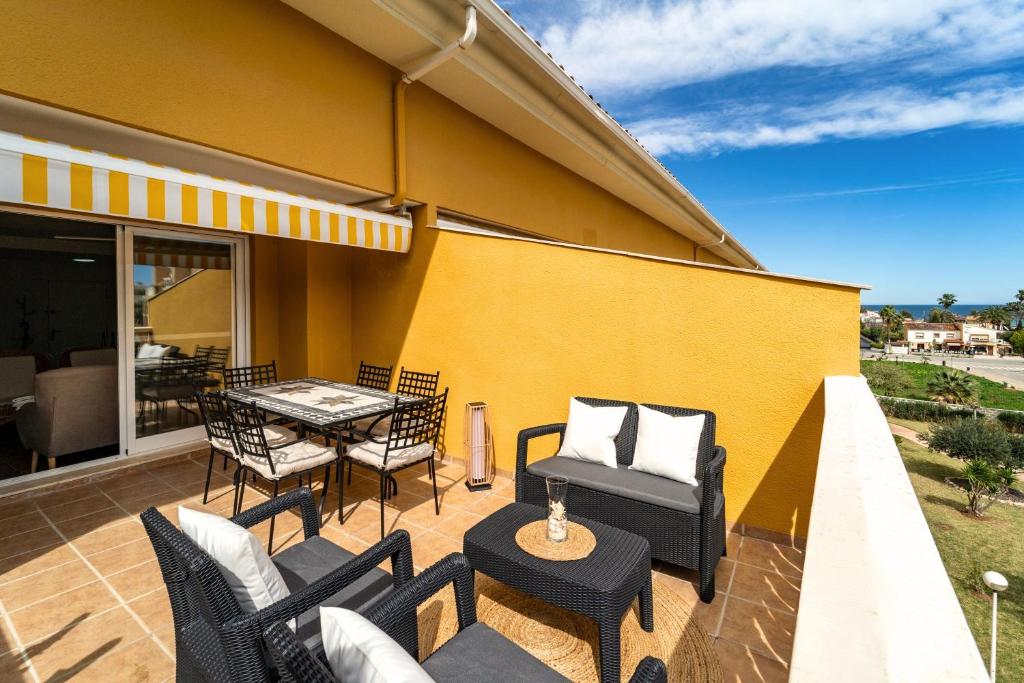 a patio with black chairs and a table and a tableablish at Attic Duplex Apartment with 4 terraces & 5 min walk to Beach in Denia