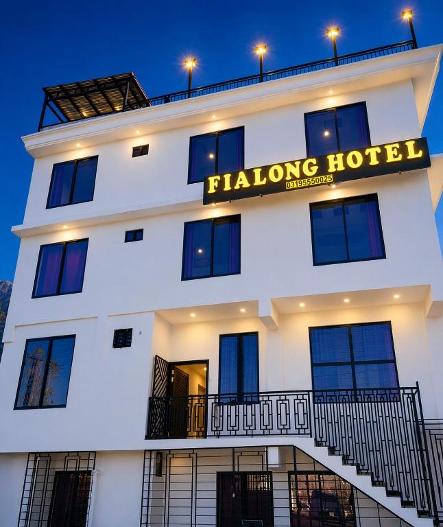 Ein weißes Gebäude mit einem Schild, auf dem „Falong Hotel“ steht. in der Unterkunft Fialong Hotel Skardu in Skardu