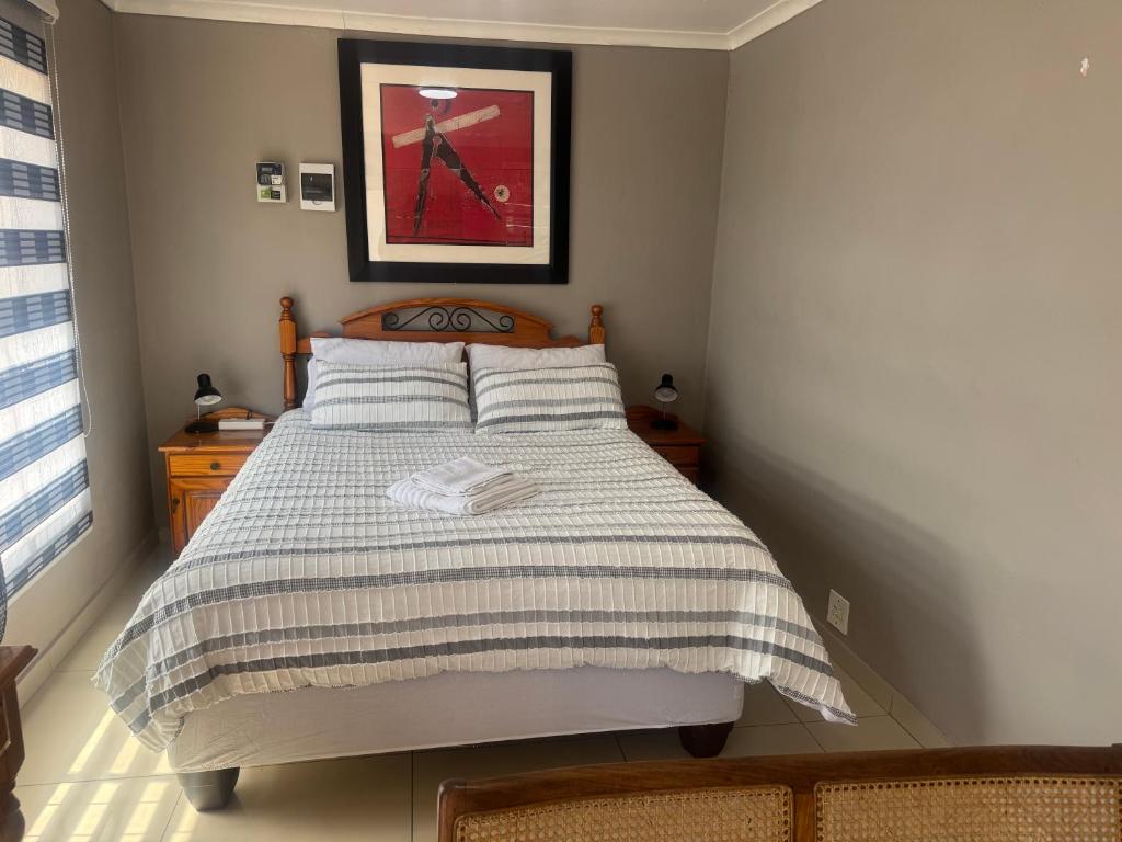 a bedroom with a bed with a striped blanket at No7 Mc Intyre Guest House in Sasolburg
