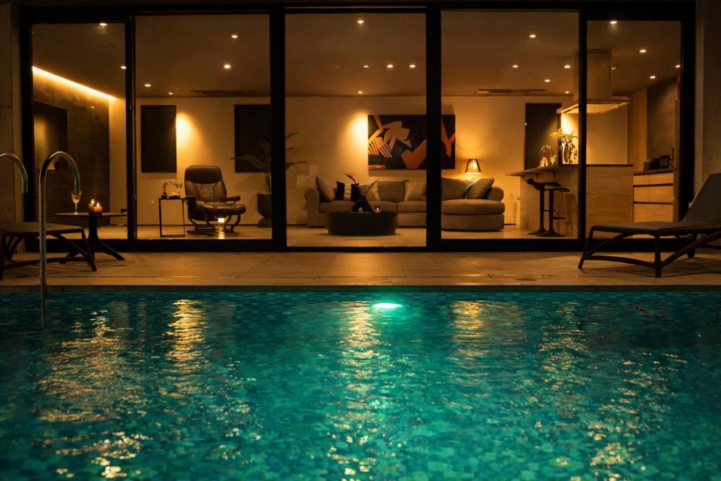 a large swimming pool in a living room at night at Gracieux Villa Lusso in Miyakojima
