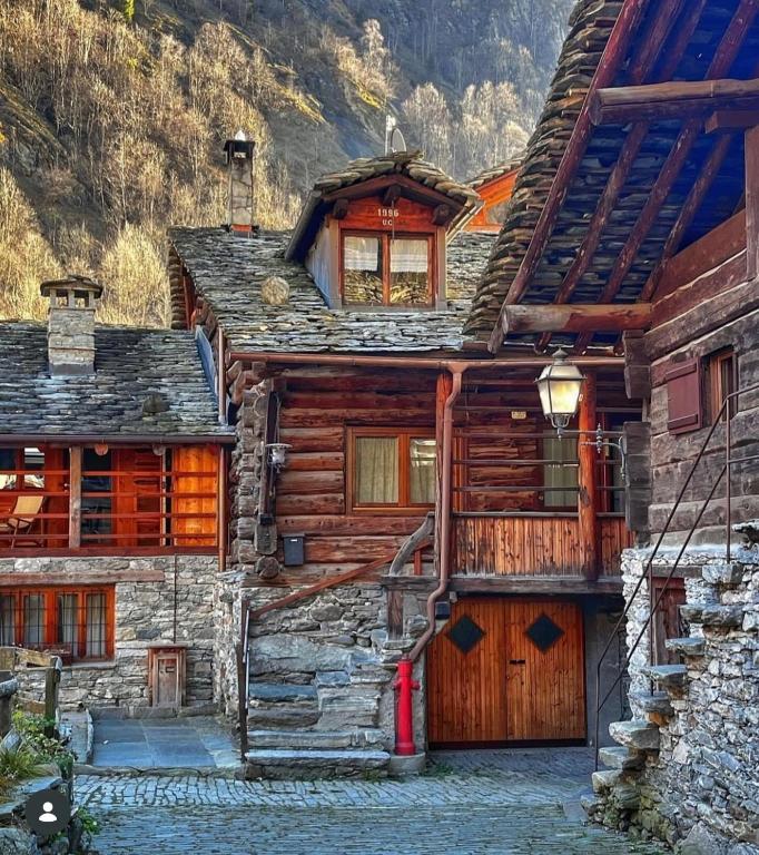 a log house with a garage and a mountain at Baita Genepy - Charme Alpino in Pietra in Alagna Valsesia