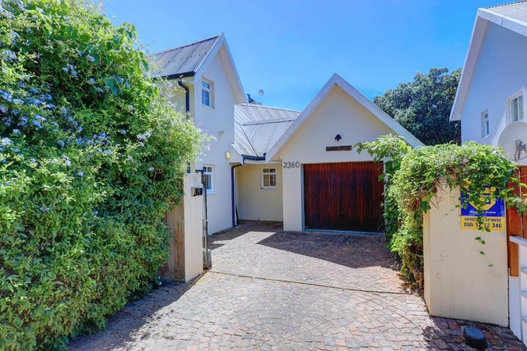 a house with a gate and a driveway at Sunbird Cottage - Wilderness in Wilderness