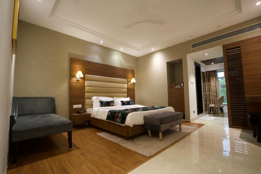 a large bedroom with a bed and a chair at RANIKOTHI BOUTiQUE HOTEL in Nagpur