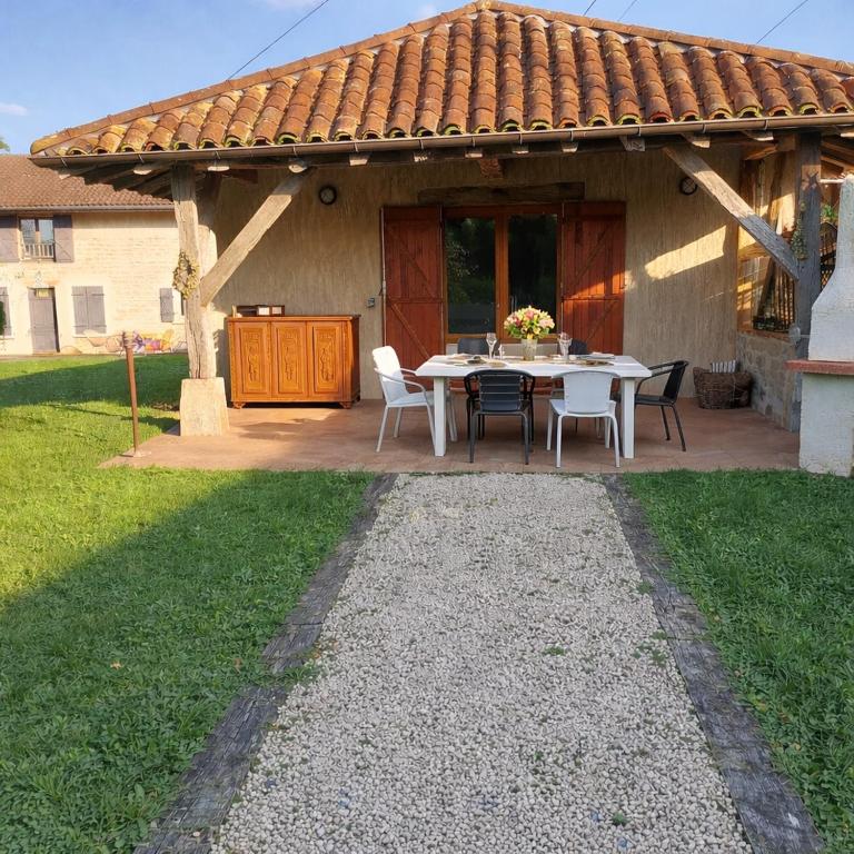 a patio with a table and chairs in front of a house at Gite de la Jument grise-calme et tranquillité in Lescheroux