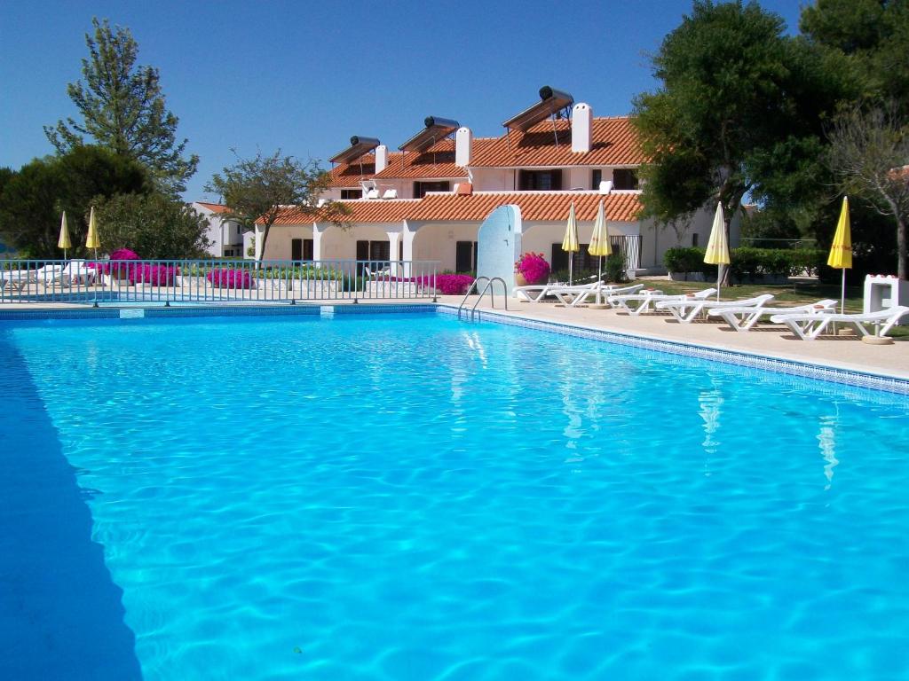 una gran piscina azul frente a una casa en Apartamentos Vale de Carros by Umbral, en Albufeira