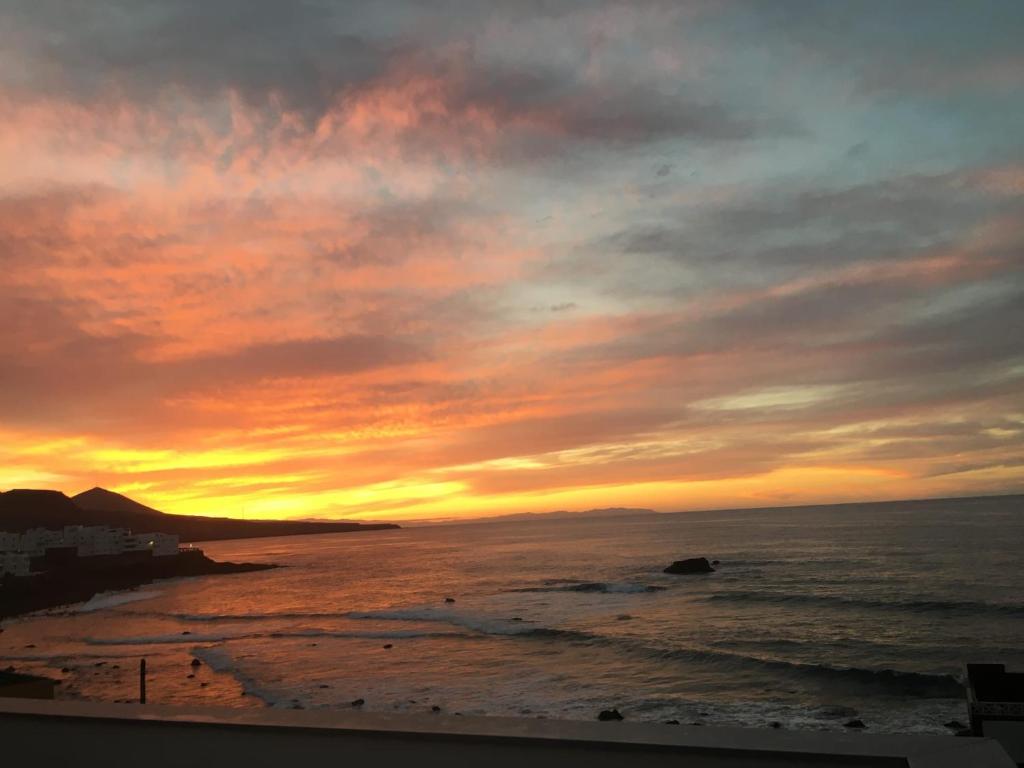 a sunset on the beach with the ocean at Casa Atardecer in Moya