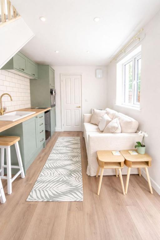 a living room with a couch and a table at Modern Cotswolds Studio in Bishops Cleeve