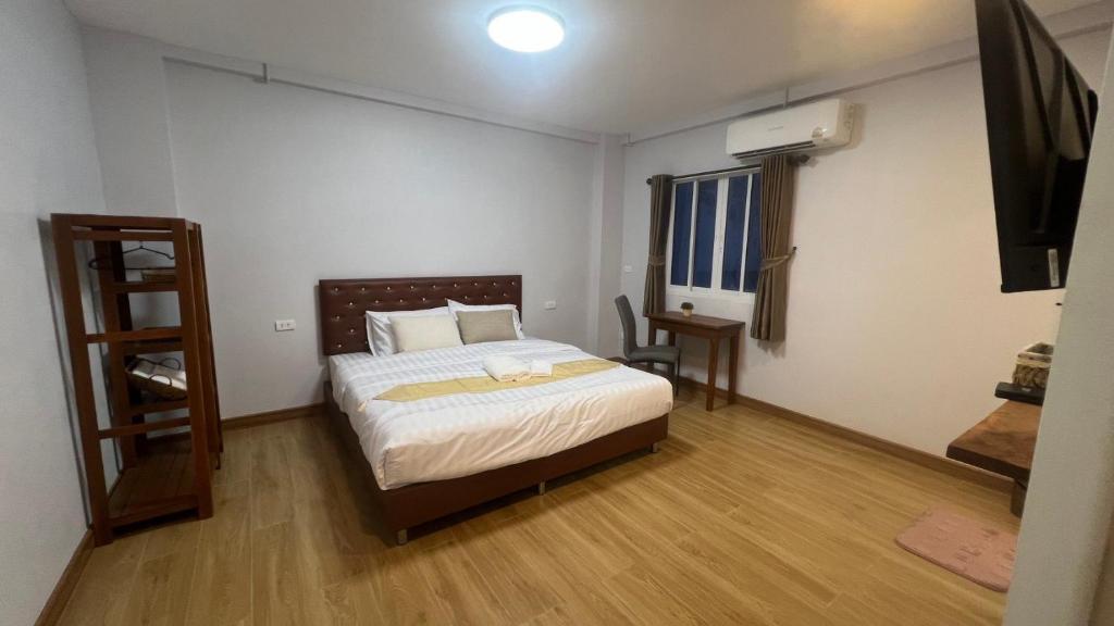 a bedroom with a bed and a table and a window at บ้านตลาด สัตหีบ in Sattahip
