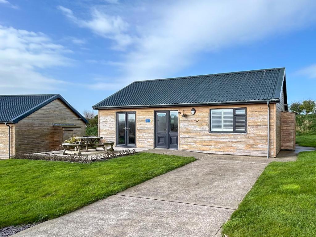 a house with a picnic table in a yard at Fern Lodge - Uk51604 in Peel