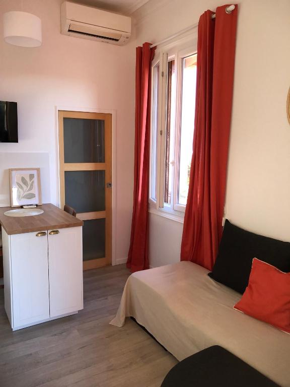 a bedroom with a bed and a window with red curtains at Un petit nid au calme, à 4 minutes de la plage ! in Banyuls-sur-Mer