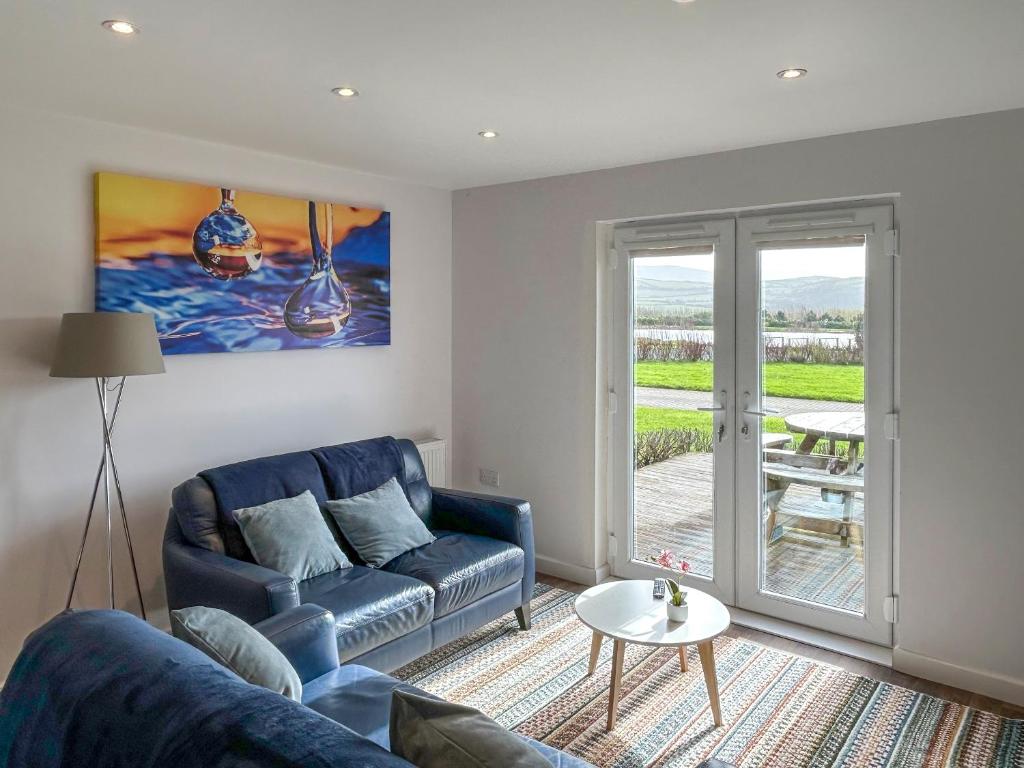 a living room with a blue couch and a table at Wisteria Lodge - Uk51605 in Peel