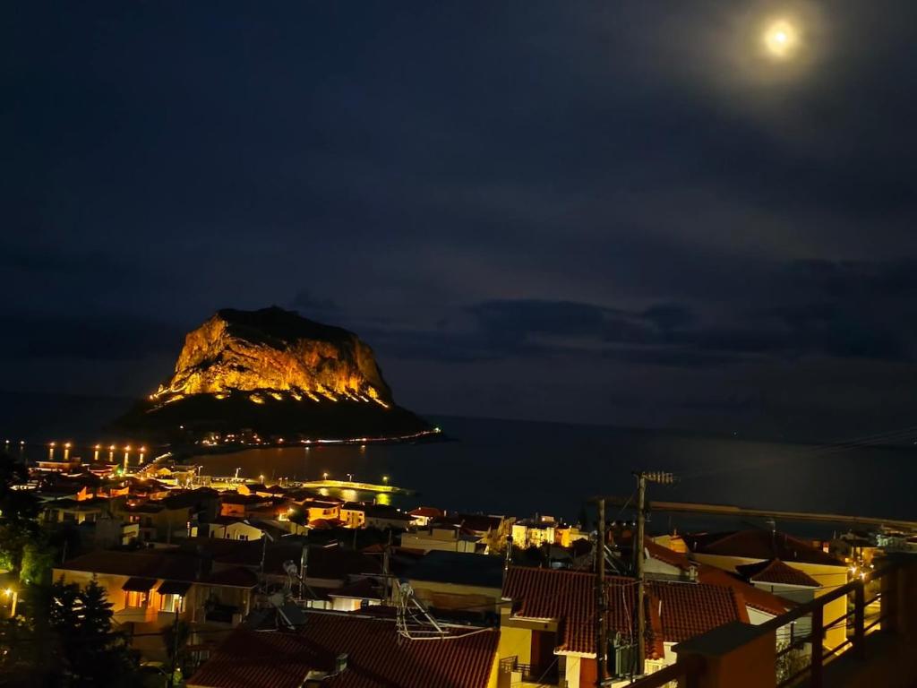 a view of a mountain at night with the moon at Blue Hour in Monemvasia