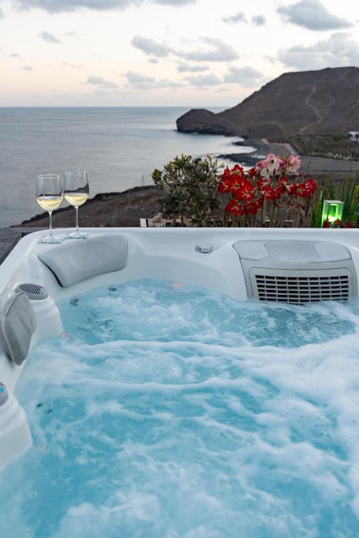 a hot tub with two glasses of wine at "El Ático Bonito"-Penthaus-Whirlpool-Atlantikblick in Las Playitas