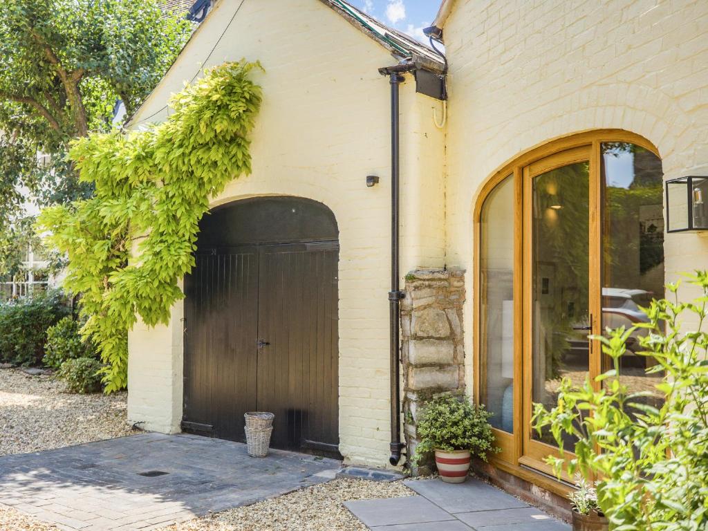 a house with a brown garage with a door at The Old Workshop - Cottage in Broom