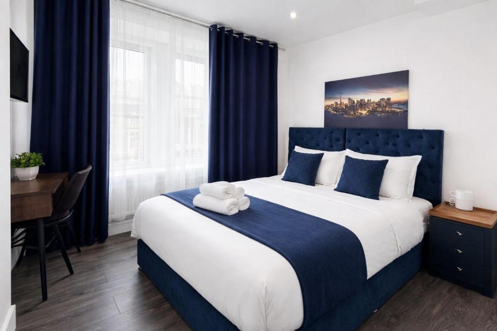 a bedroom with a large bed with a teddy bear on it at The Broadway Hotel - London Heathrow in Southall
