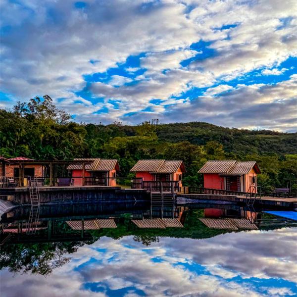 a group of houses on a bridge over a body of water at Pousada Via Láctea in Três Cachoeiras