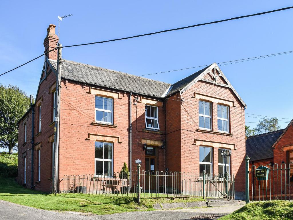 a red brick house with a fence in front of it at Farndale Apartment in Commondale