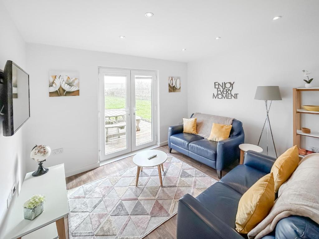 a living room with a blue couch and a table at Primrose Lodge - Uk51602 in Peel