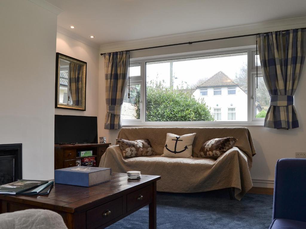 a living room with a couch and a large window at Sea Breezes in Totland
