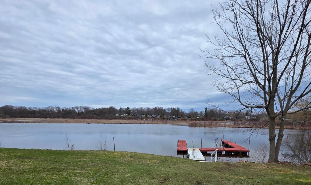 a dock on a lake with two chairs on it at Riverside Vista in Pulaski
